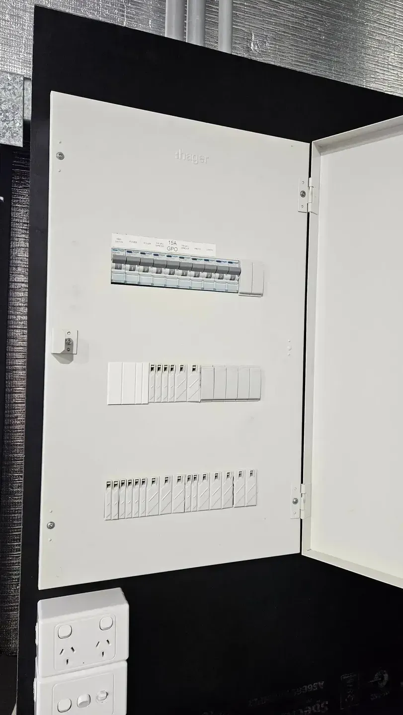 Electrical Panel With White Breakers Inside a Black Cabinet — Lit Energy in Rural View, QLD