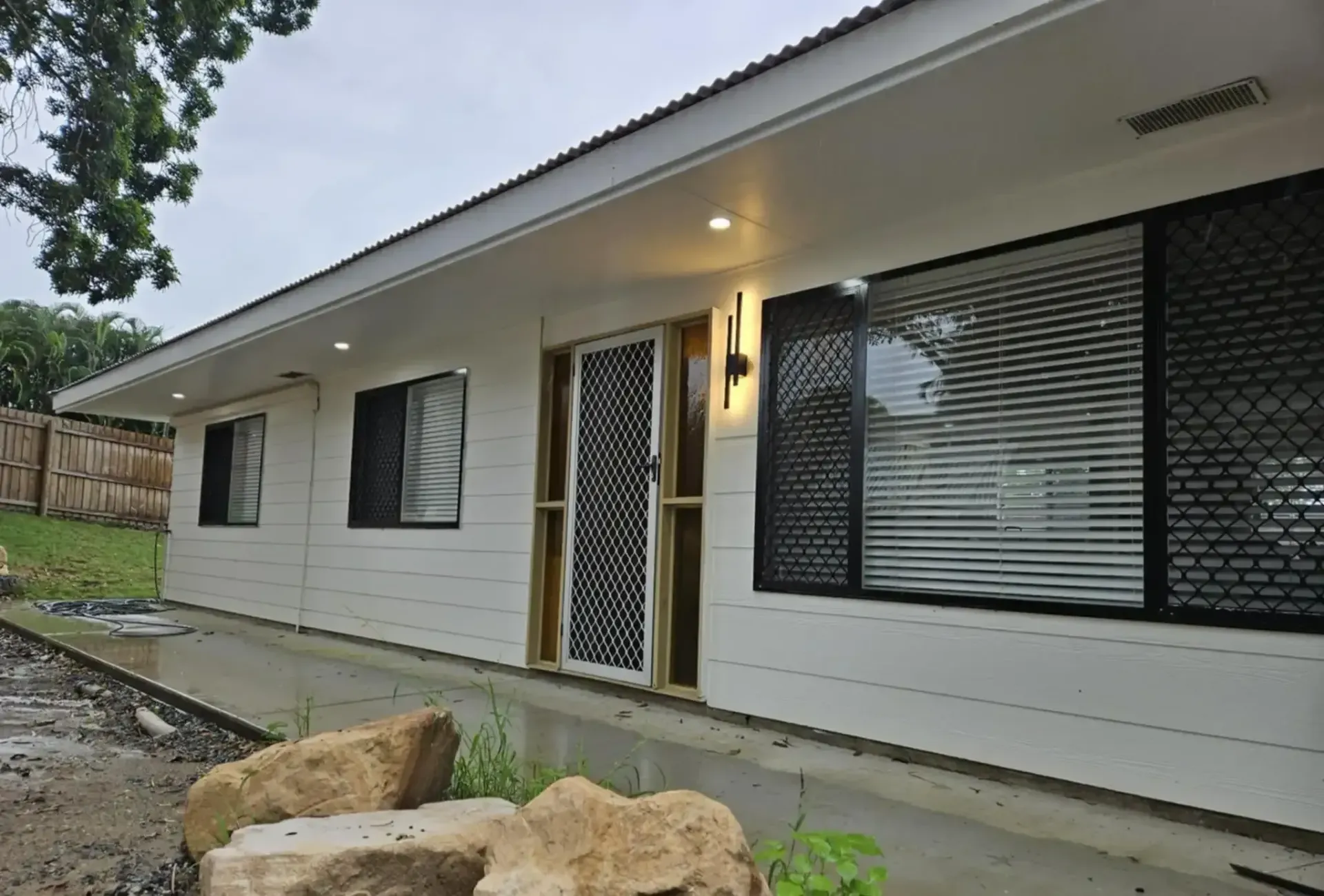 White house with black framed windows, and security door — Lit Energy in Marian, QLD