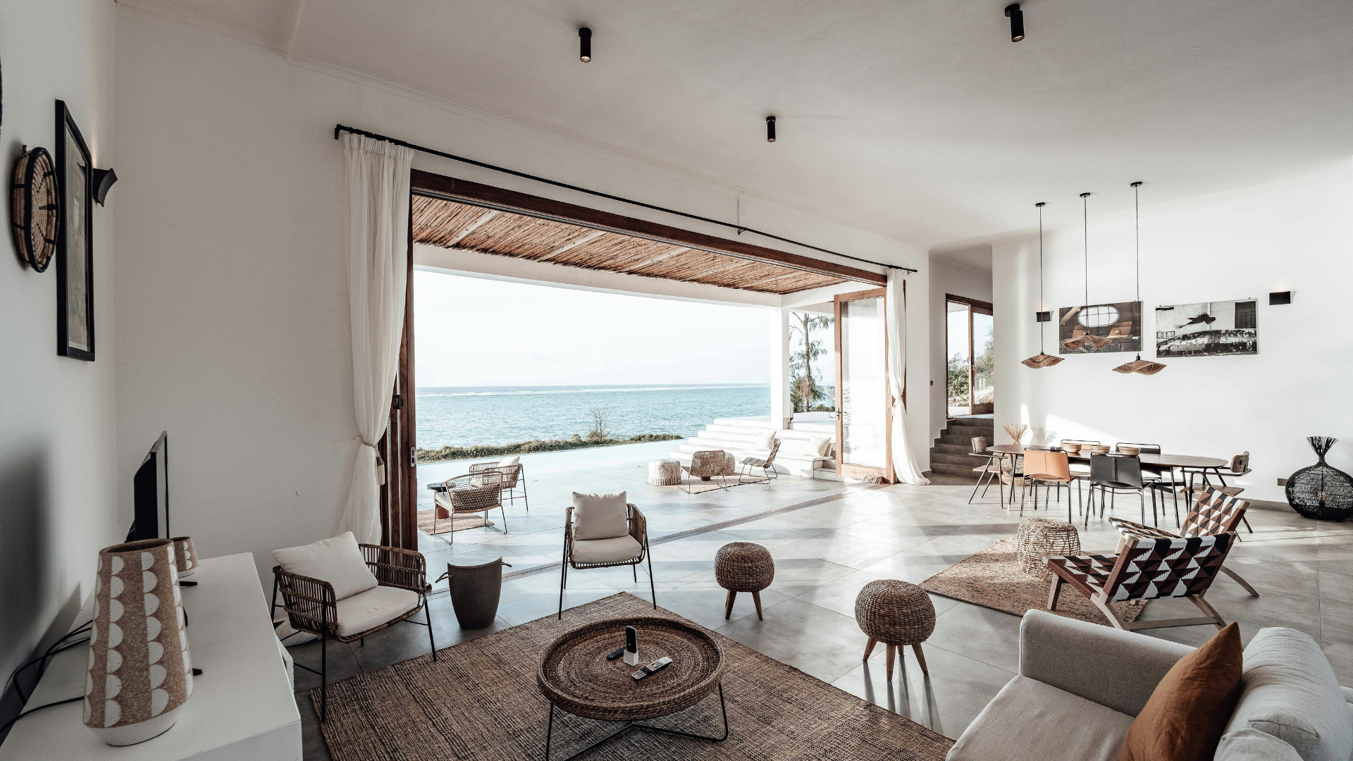 Modern kitchen with dark wood cabinets, white countertops, and an island with a sink.