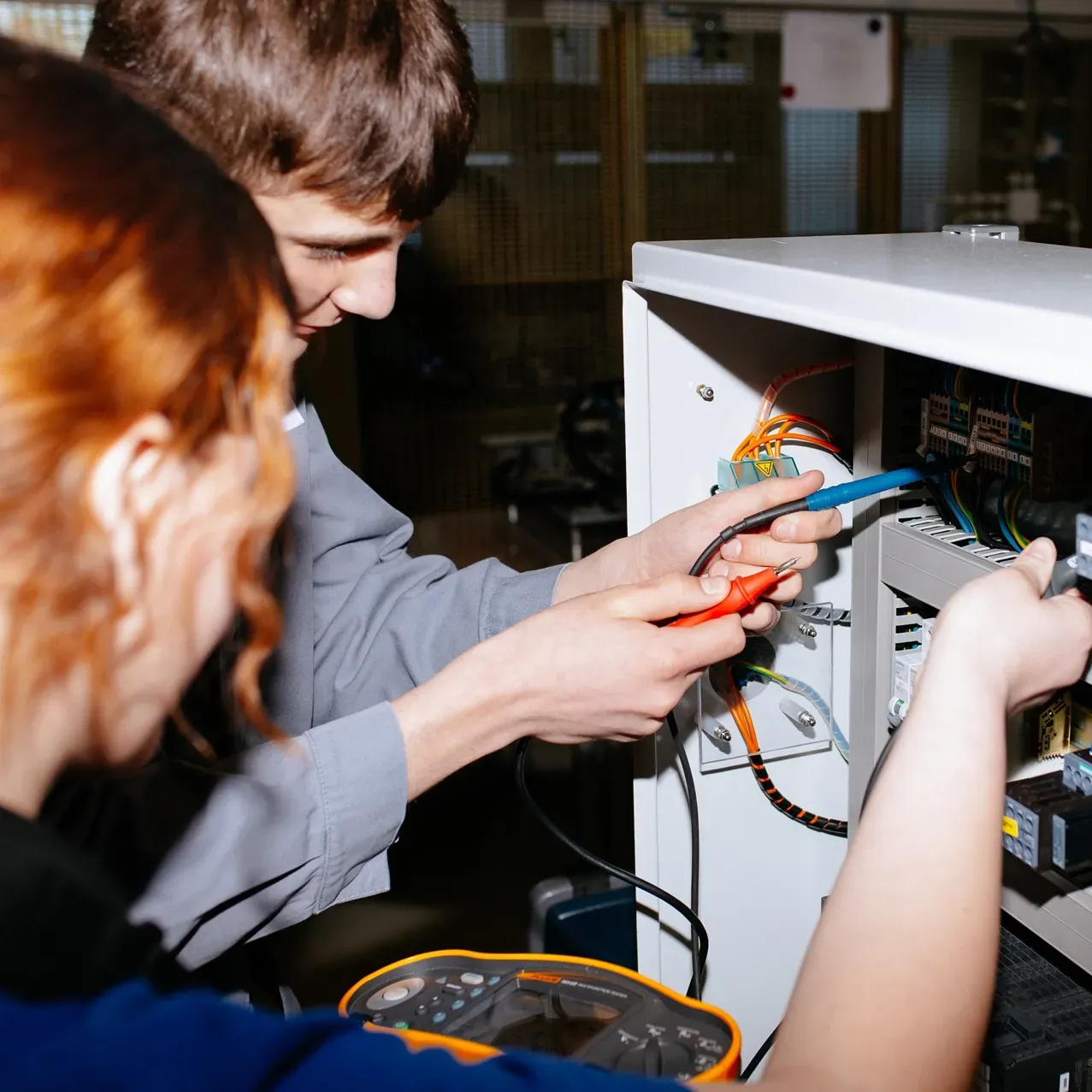 A man and a woman are working on an electronic device
