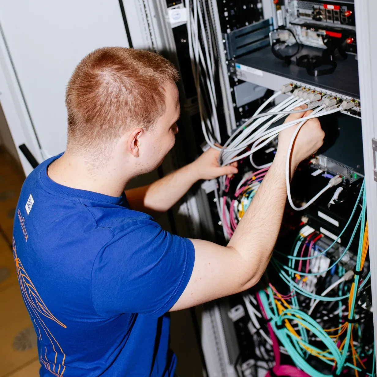 A man in a blue shirt is working on a server