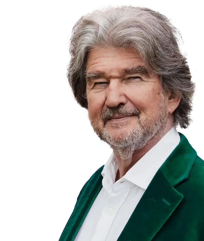 A man with gray hair and a beard is wearing a green jacket