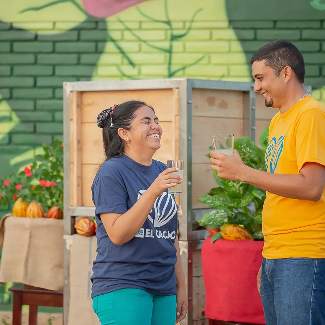 A man in a yellow shirt is talking to a woman in a blue shirt that says el rancho