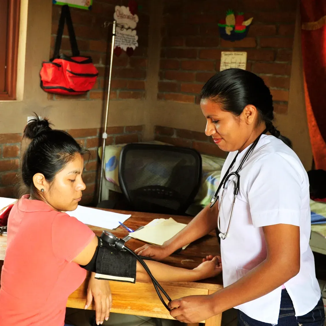 A nurse measures a woman's blood pressure