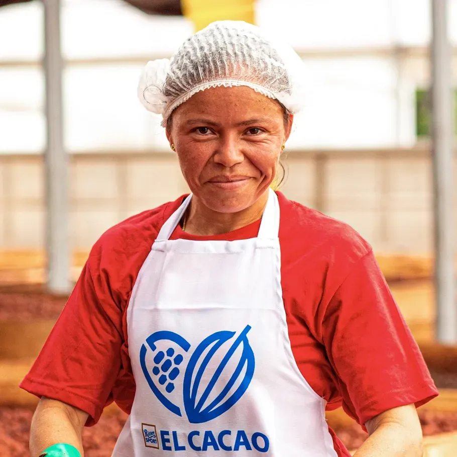 A woman wearing an apron that says elcacao on it