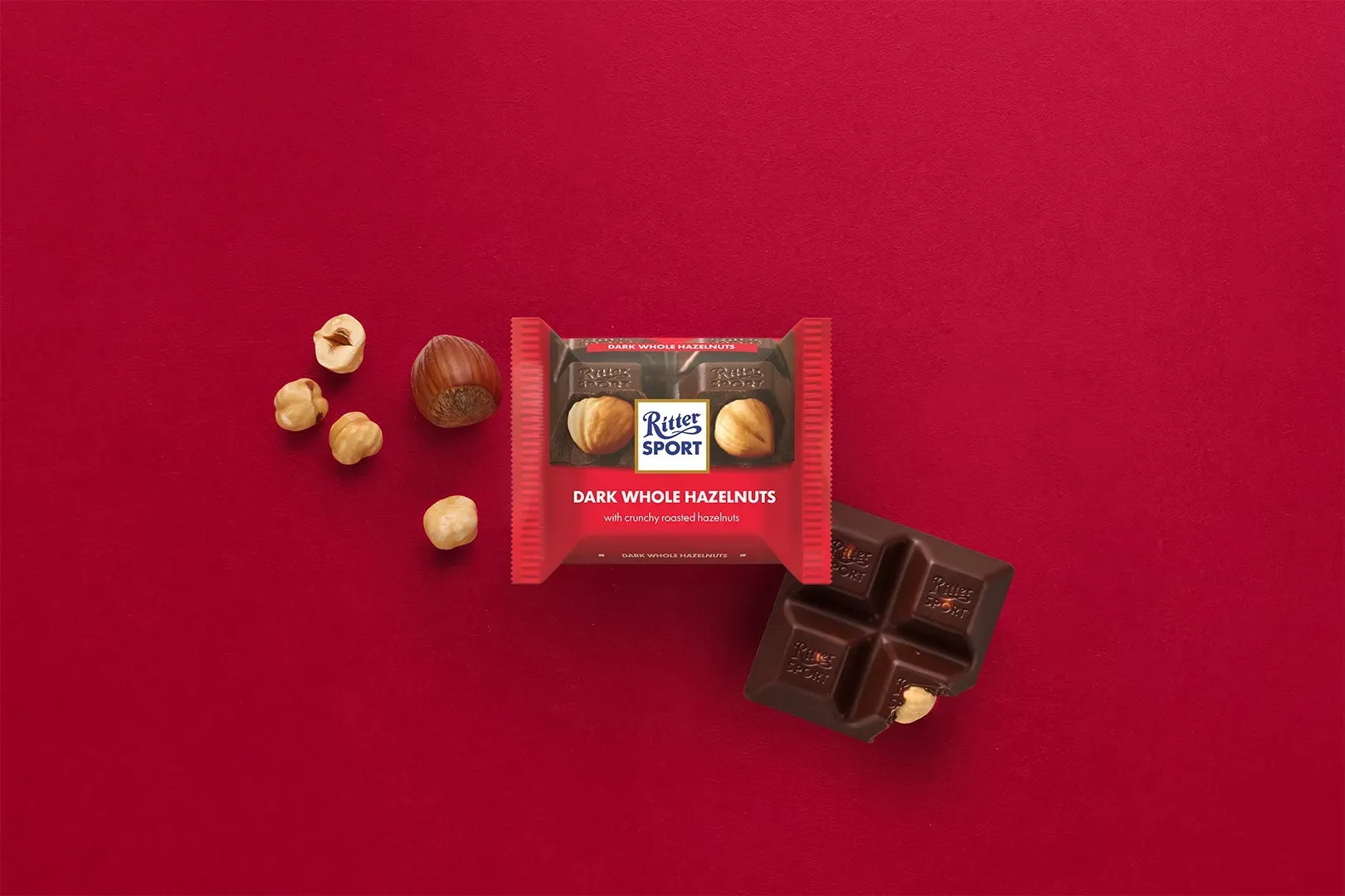 Ritter Sport chocolate bar packaging with cocoa beans, broken chocolate, and milk on a blue background.