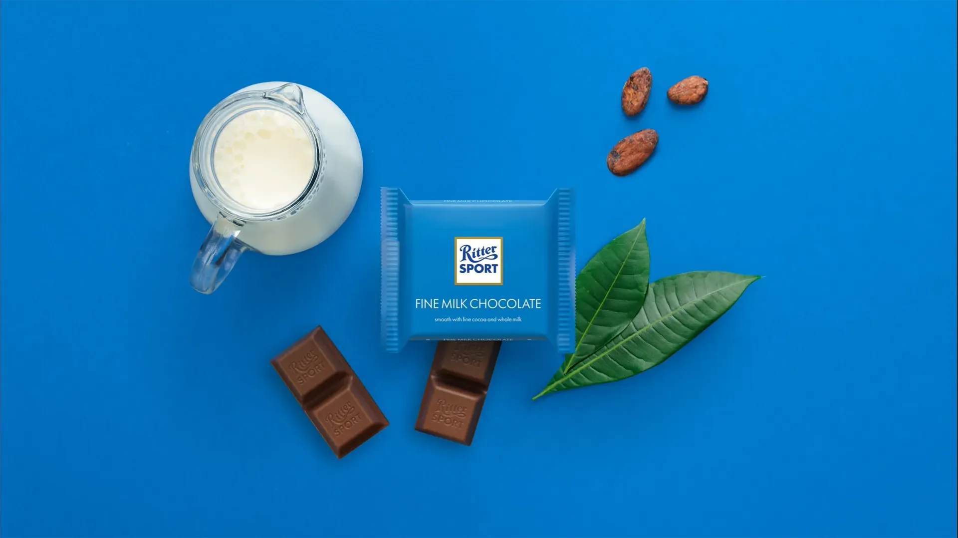 Ritter Sport chocolate bar packaging with cocoa beans, broken chocolate, and milk on a blue background.
