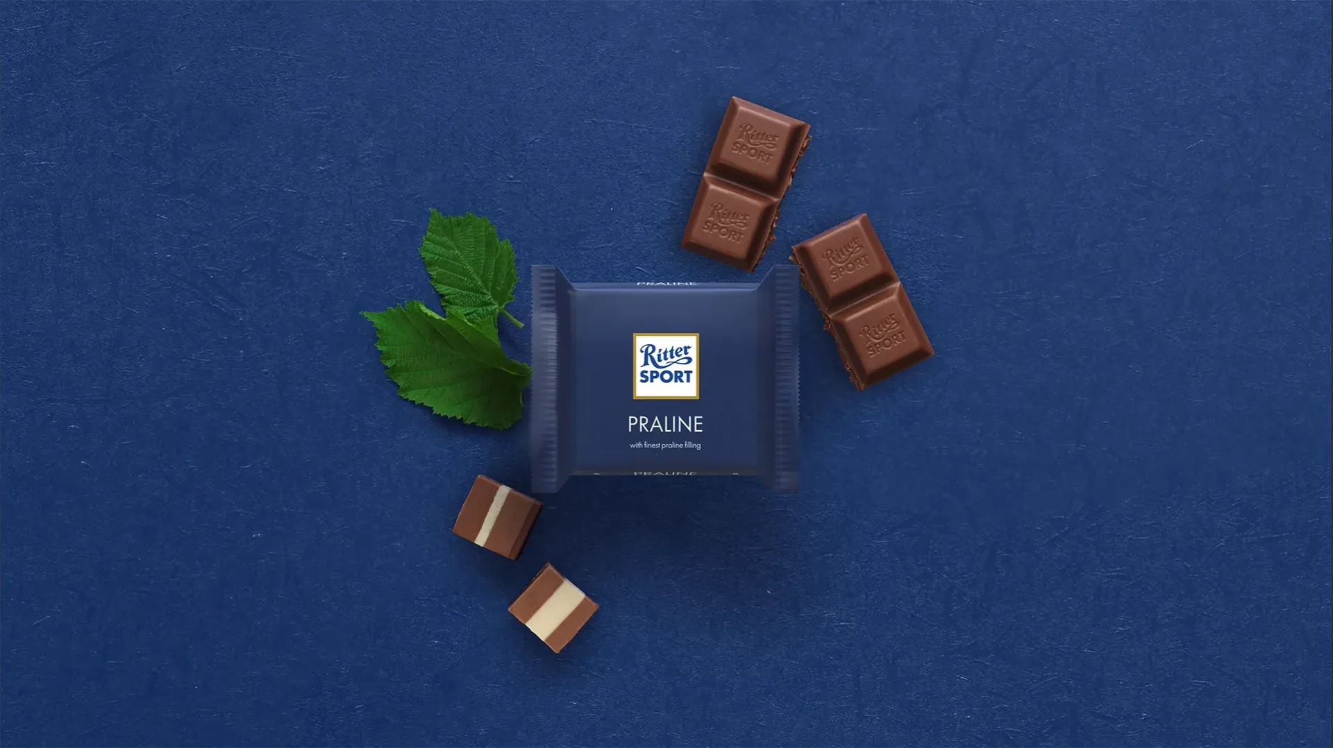 Ritter Sport chocolate bar packaging with cocoa beans, broken chocolate, and milk on a blue background.