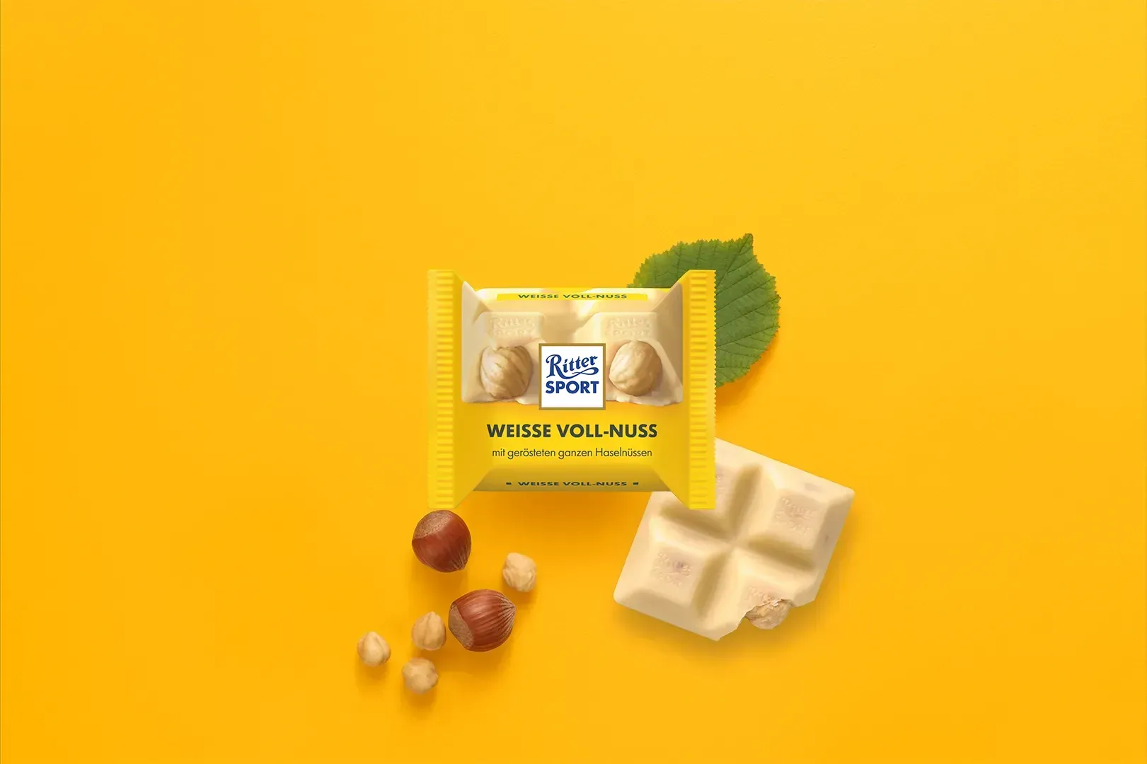 Verpackung einer blauen Schokoladentafel mit Nüssen, Schokoladenstückchen und dem Hinweis „55 % Kakaoanteil“ auf blauem Hintergrund