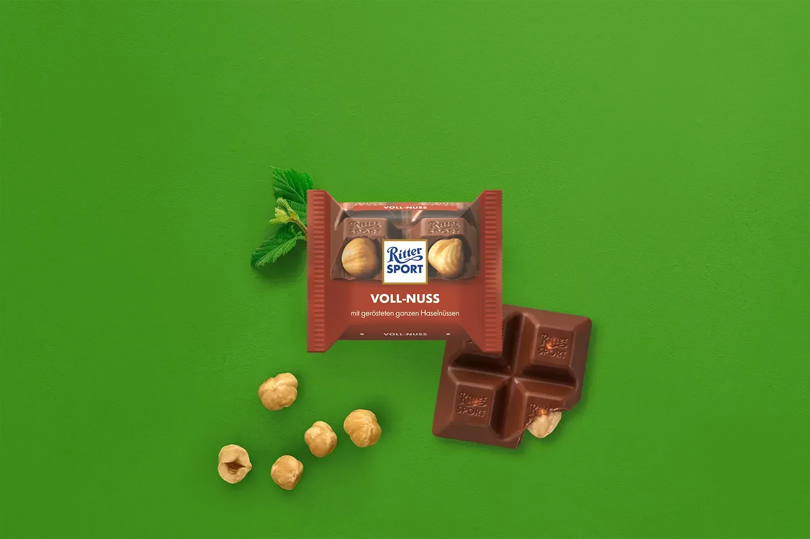 Verpackung einer blauen Schokoladentafel mit Nüssen, Schokoladenstückchen und dem Hinweis „55 % Kakaoanteil“ auf blauem Hintergrund