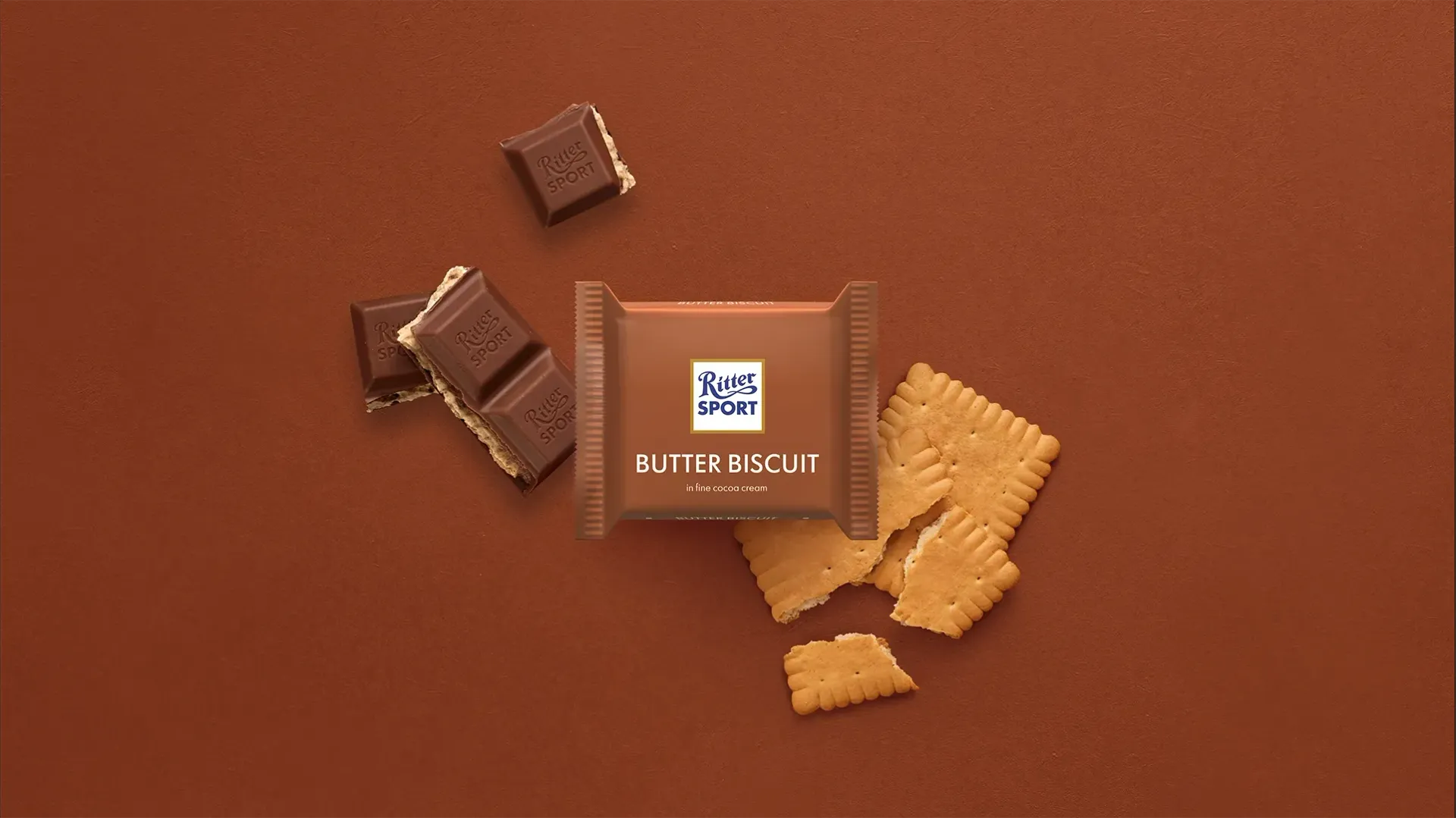 Ritter Sport chocolate bar packaging with cocoa beans, broken chocolate, and milk on a blue background.
