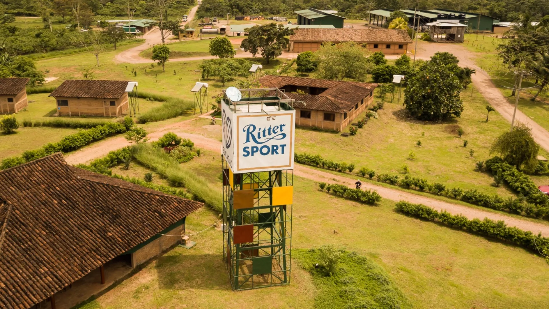 Eine Luftaufnahme eines Dorfes mit einem Turm, auf dem steht: „Ritter Sport“