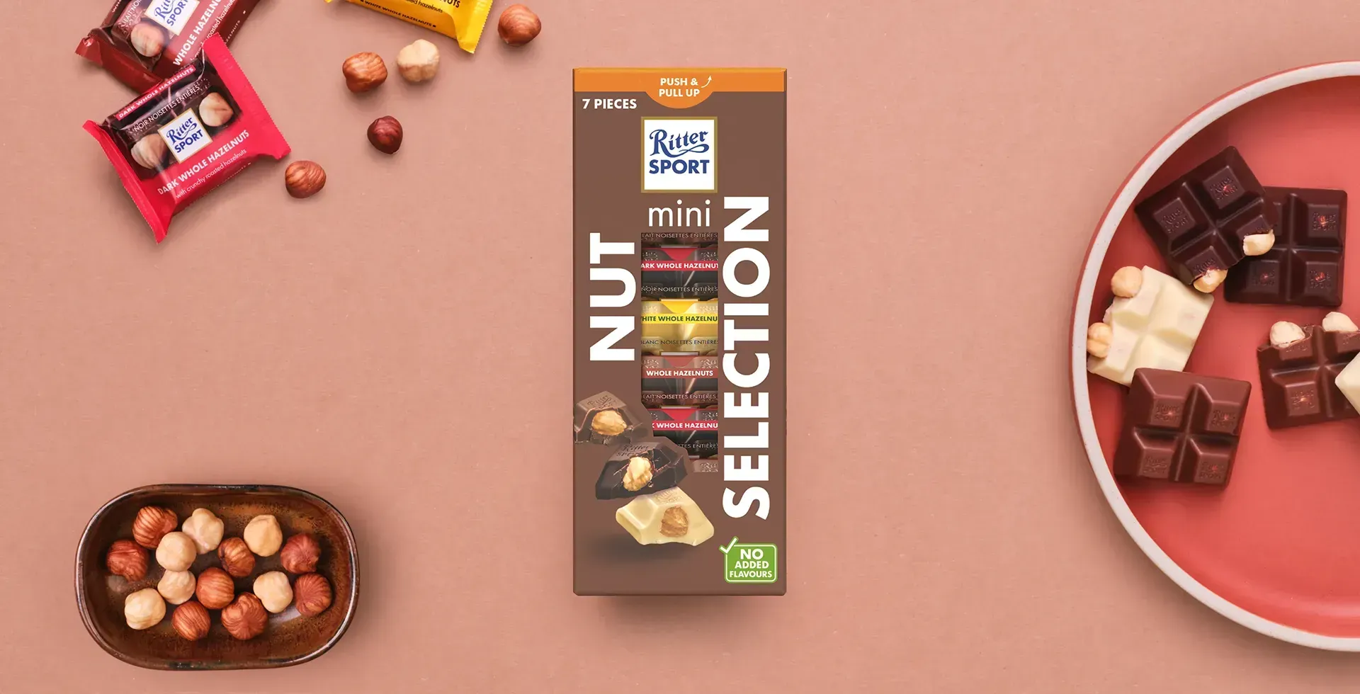 Ritter Sport chocolate bar packaging with cocoa beans, broken chocolate, and milk on a blue background.