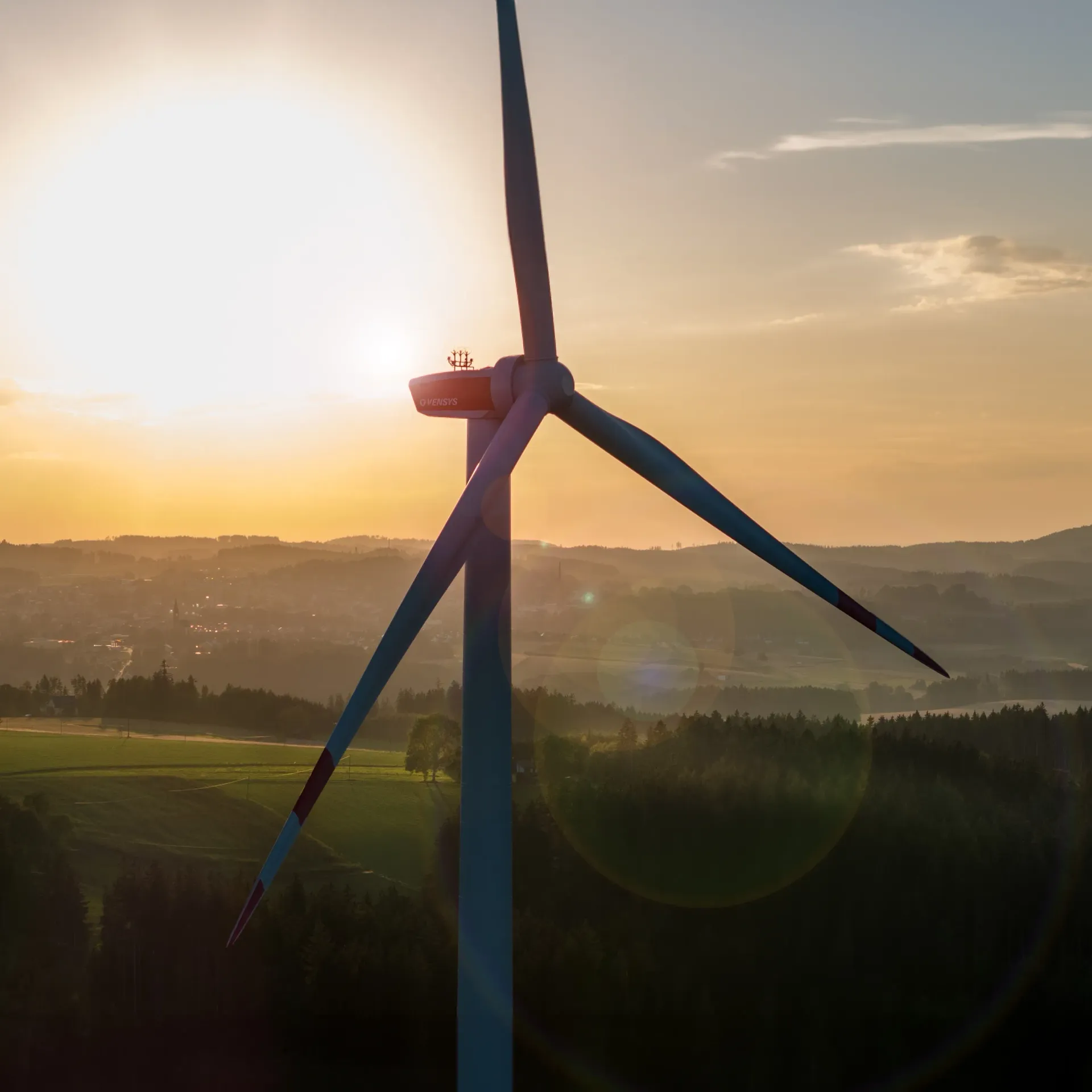 An aerial view of a wind turbine at sunset