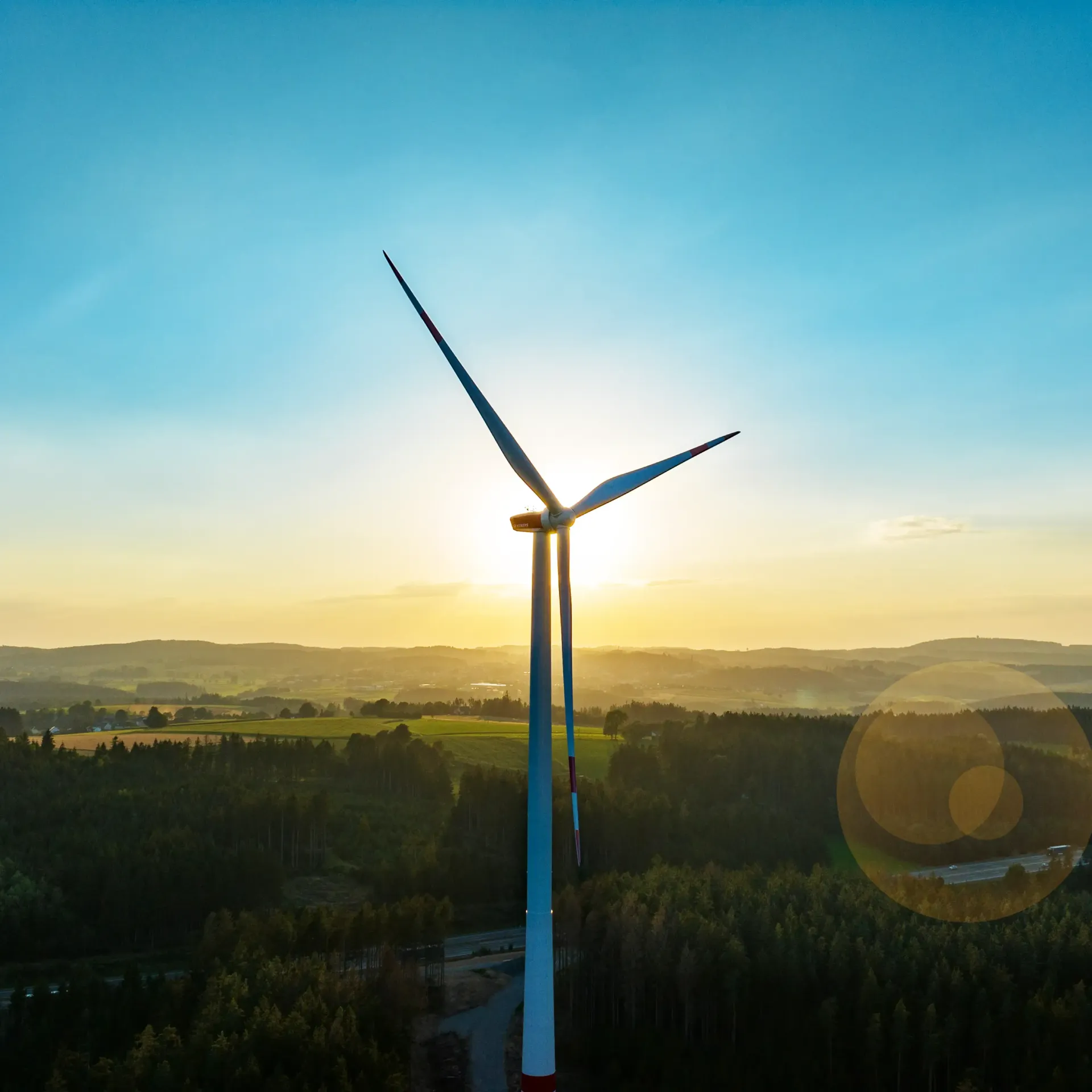 An aerial view of a wind turbine at sunset