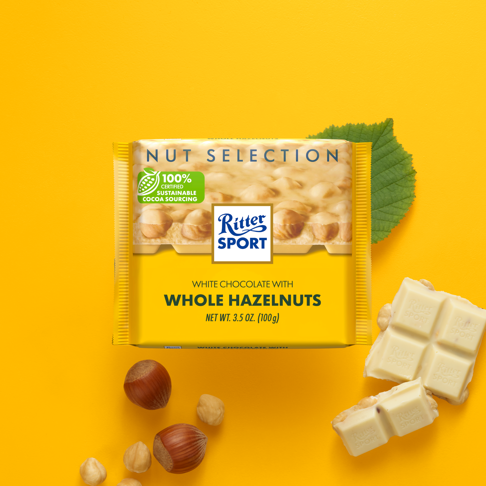 Ritter Sport white chocolate bar with hazelnuts on yellow background; includes hazelnuts and leaf.