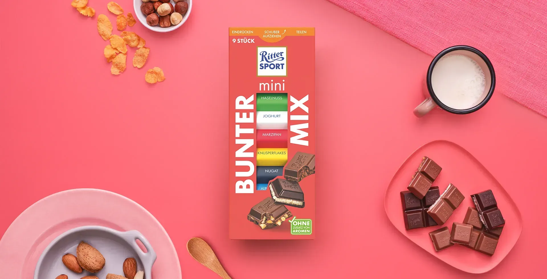 Verpackung einer blauen Schokoladentafel mit Nüssen, Schokoladenstückchen und dem Hinweis „55 % Kakaoanteil“ auf blauem Hintergrund