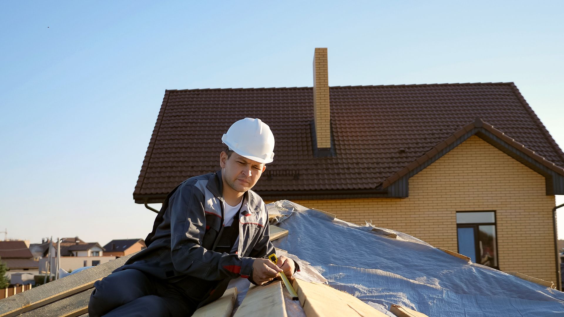 A man is working on the roof of a house.