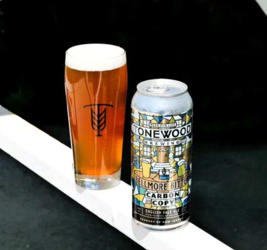 A glass of amber beer next to a can of