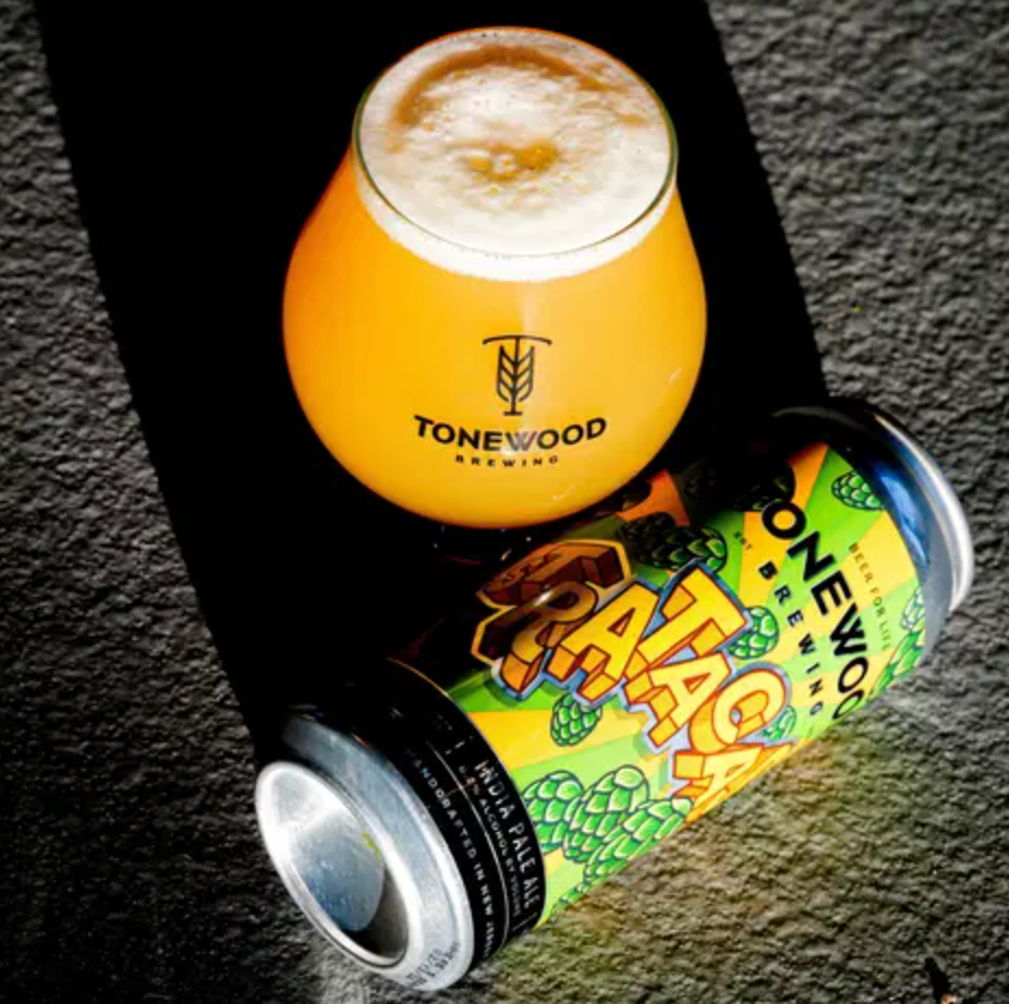 Glass of beer with foam, atop a can of