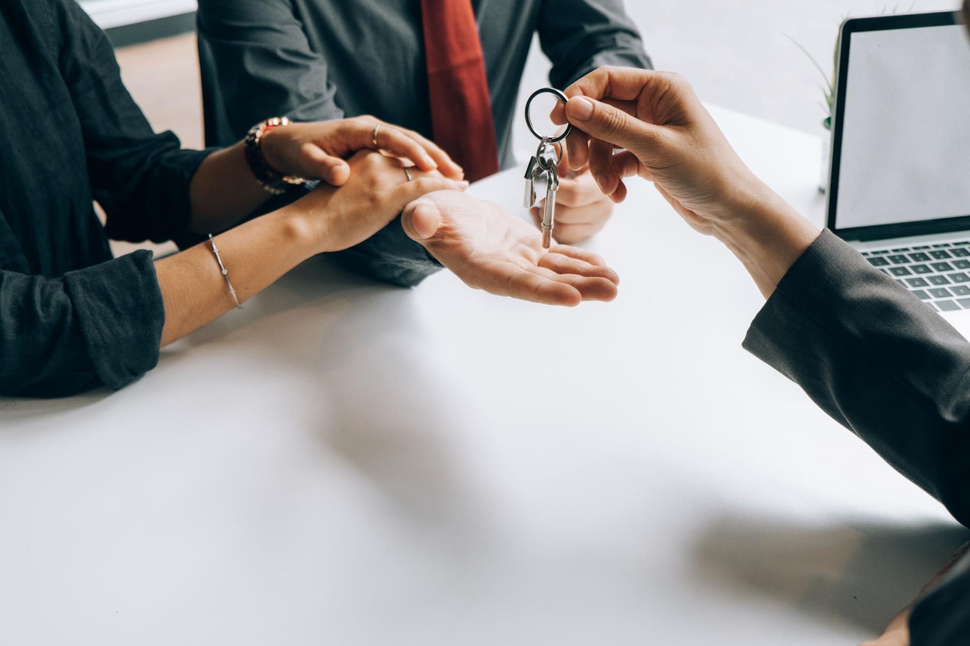 A man is giving a woman a set of keys.