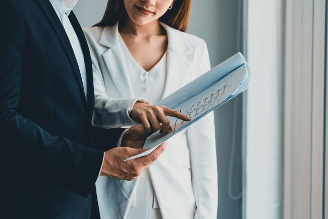 A man and a woman are looking at a piece of paper.