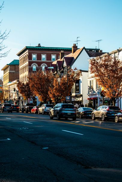 A busy city street with a lot of cars parked on the side of the road.
