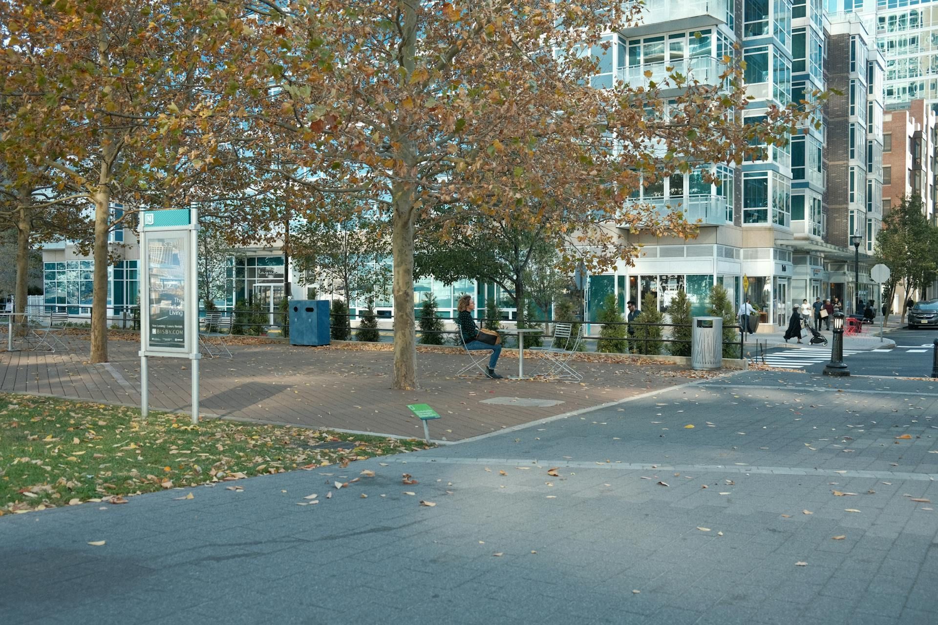 A person is standing in a park in front of a building