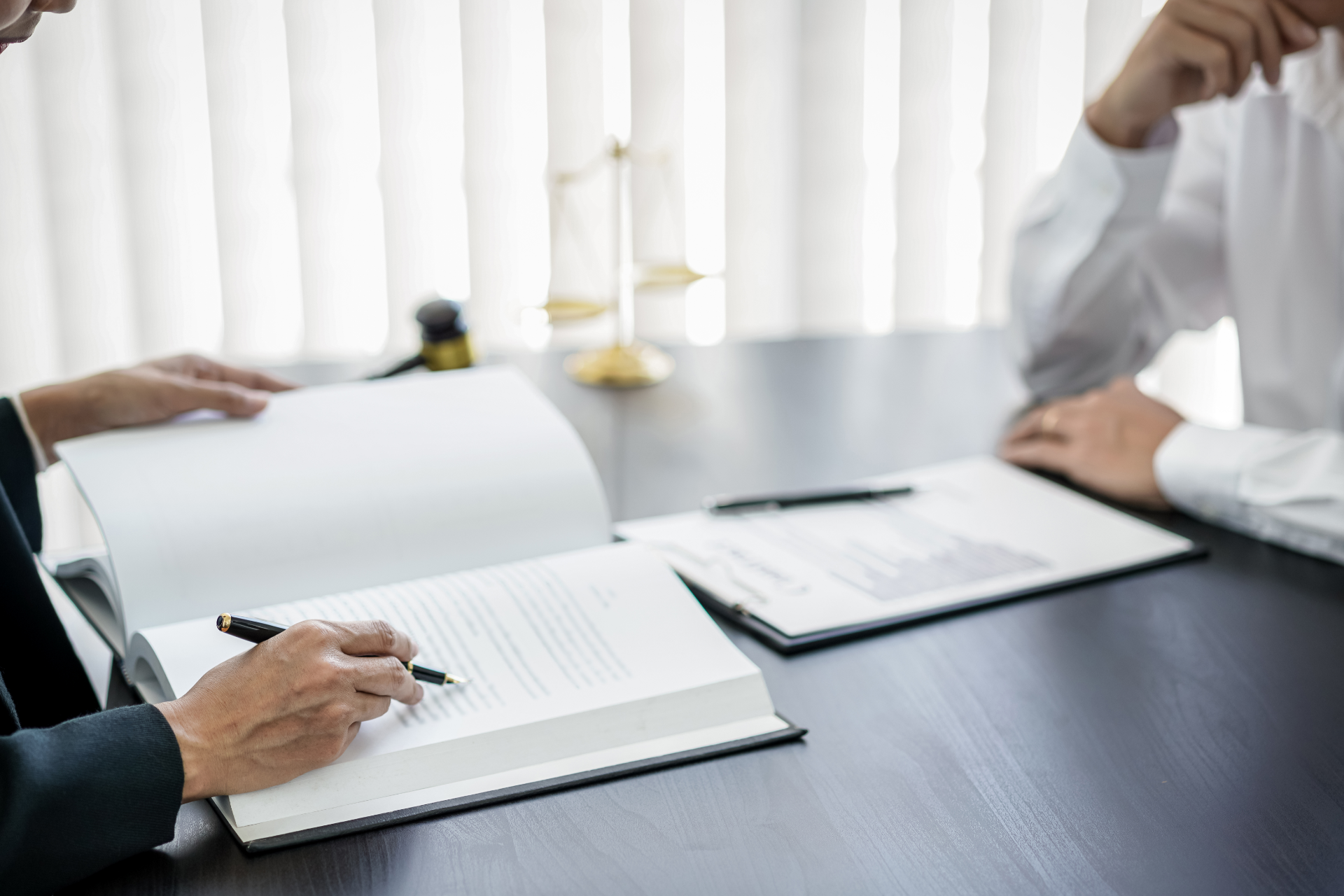 Lawyer signing documents with a client in an office setting.
