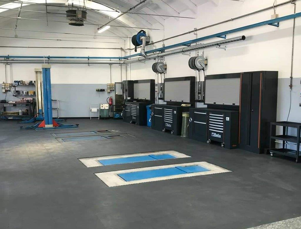 due mani di un meccanico con un cacciavite a t al lavoro su un motore