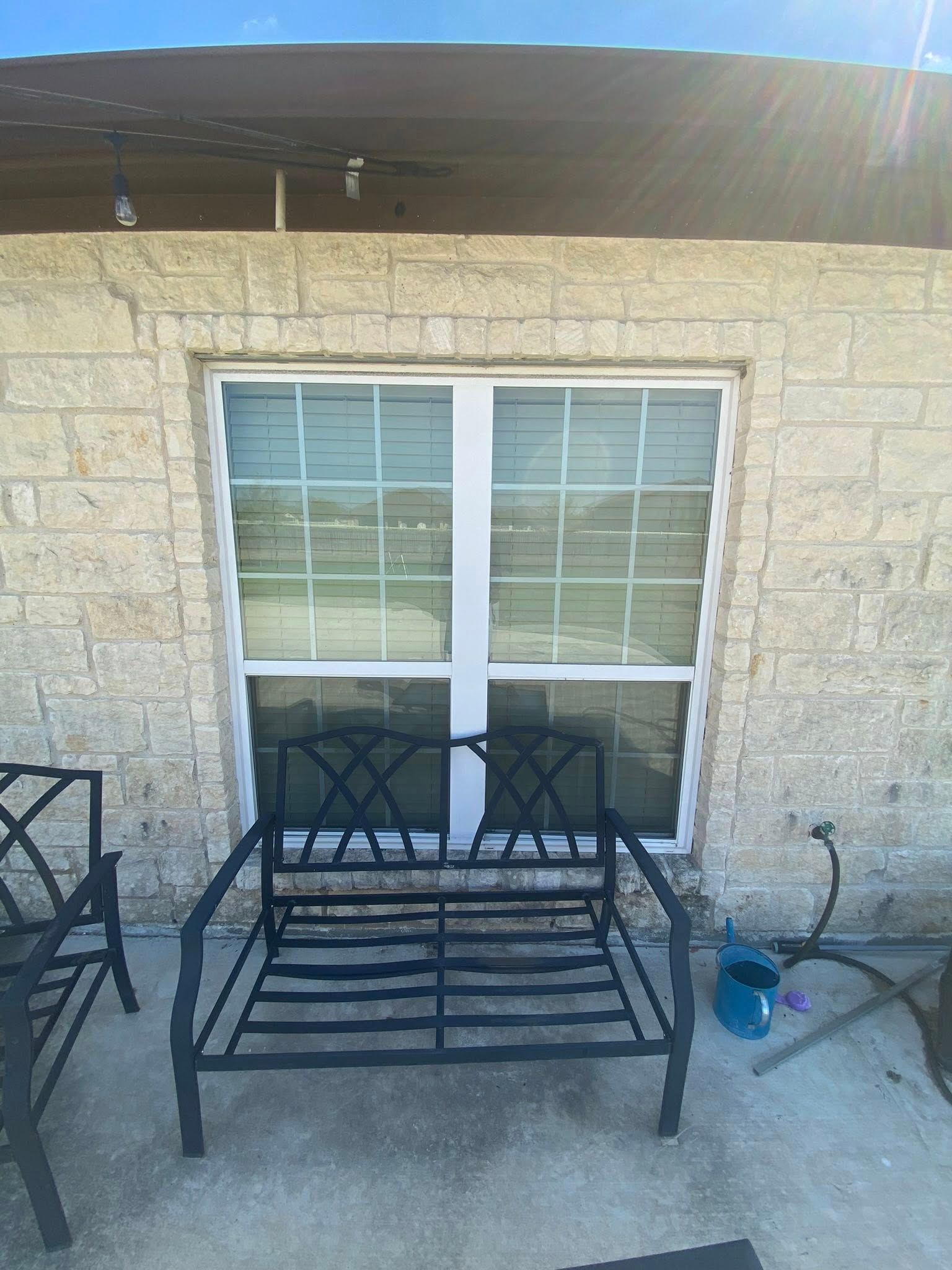 A bench is sitting in front of a sliding glass door.
