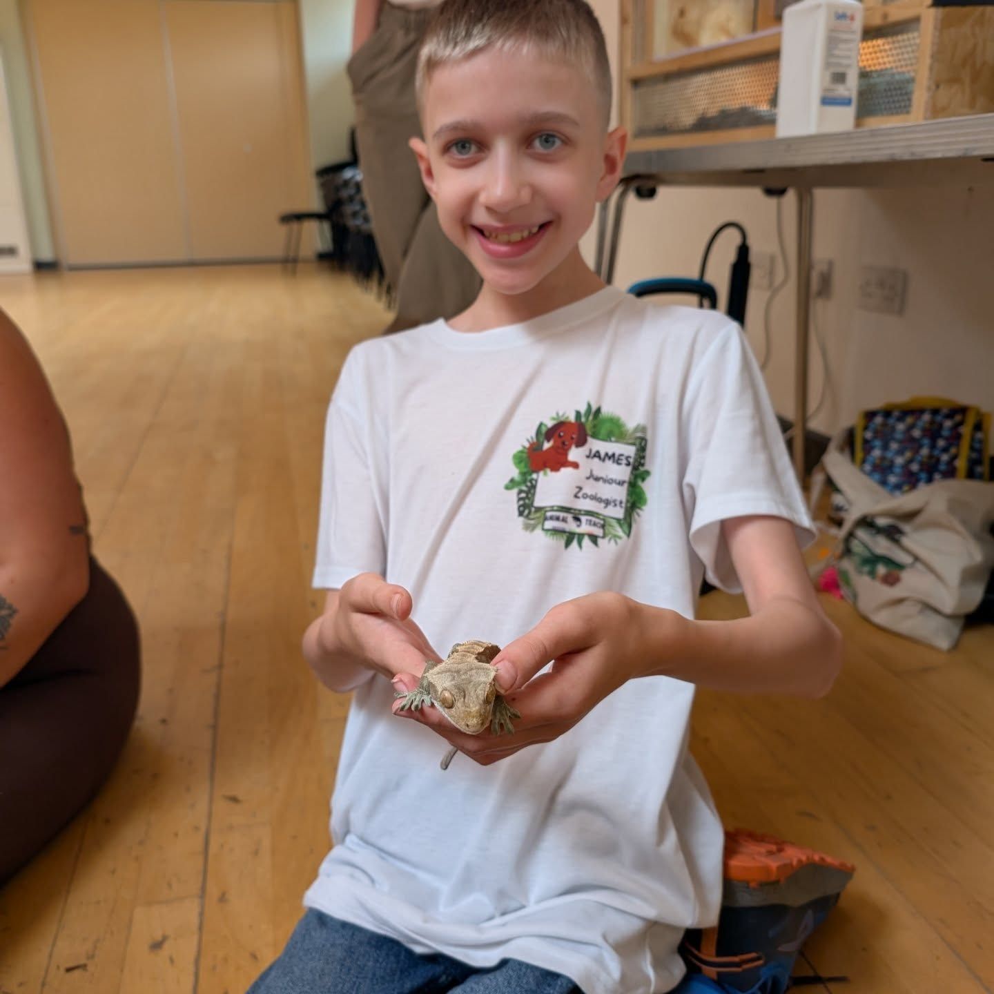 Young boy holding a gecko in his hand
