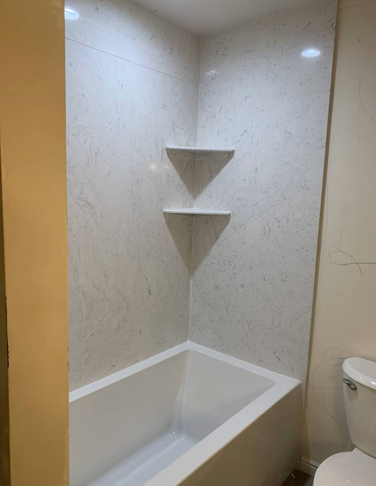 A bathroom with a bathtub , toilet and shower.