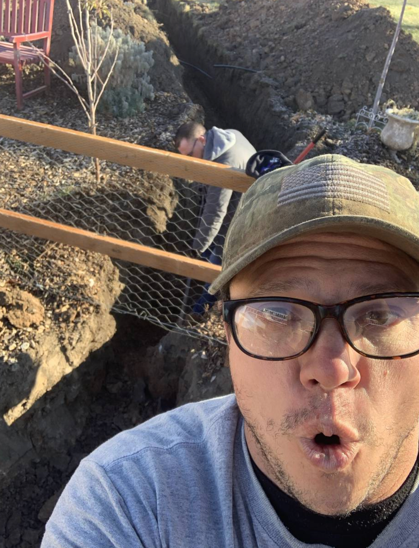 A man wearing glasses and a hat is making a funny face