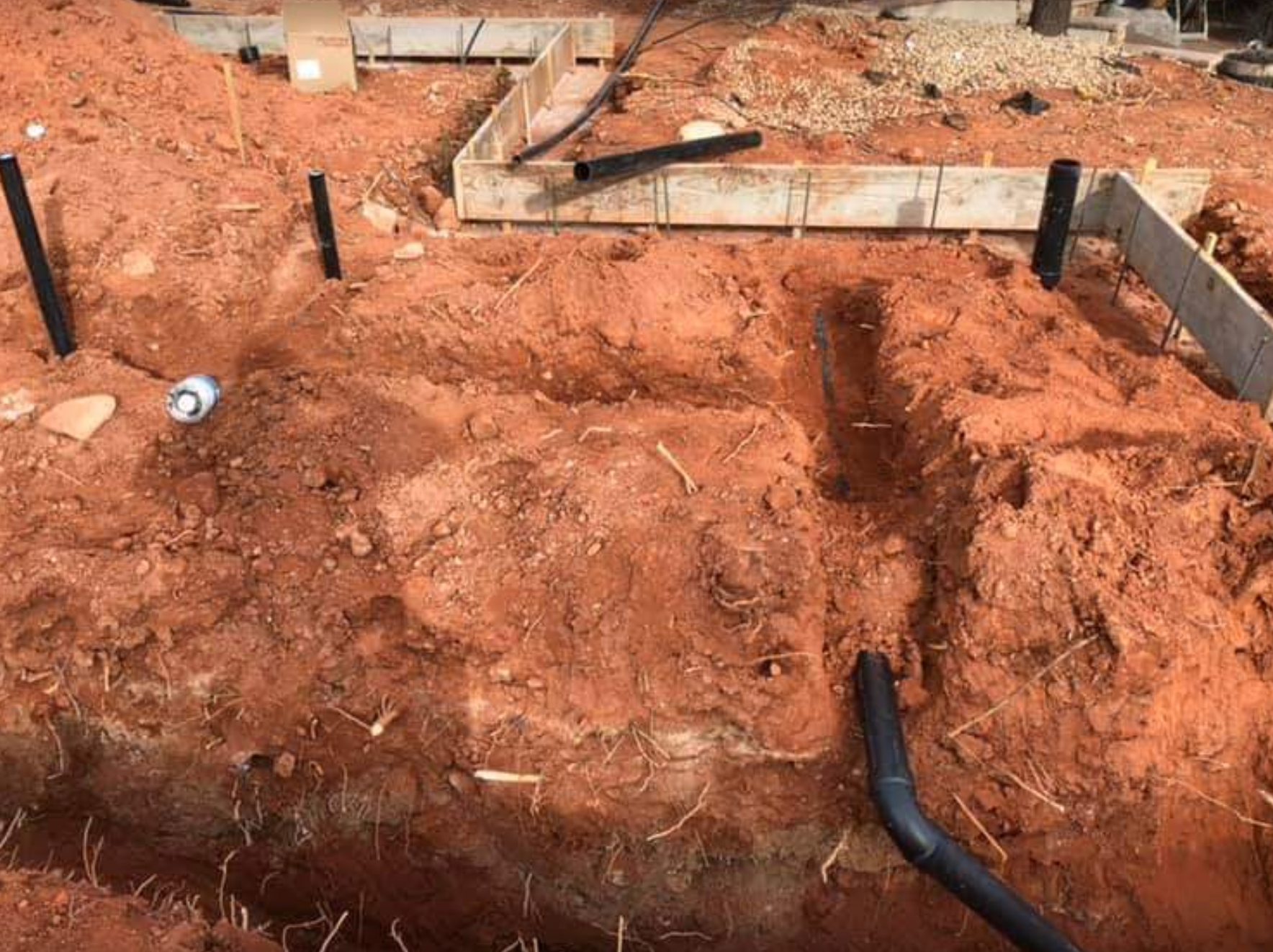 A construction site with a lot of dirt and pipes in it.