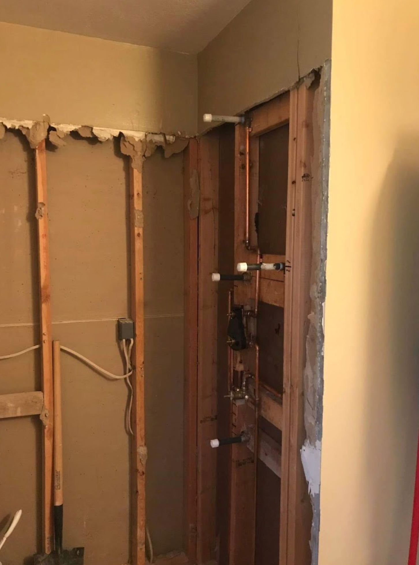 A room with wooden walls and a shovel in it.