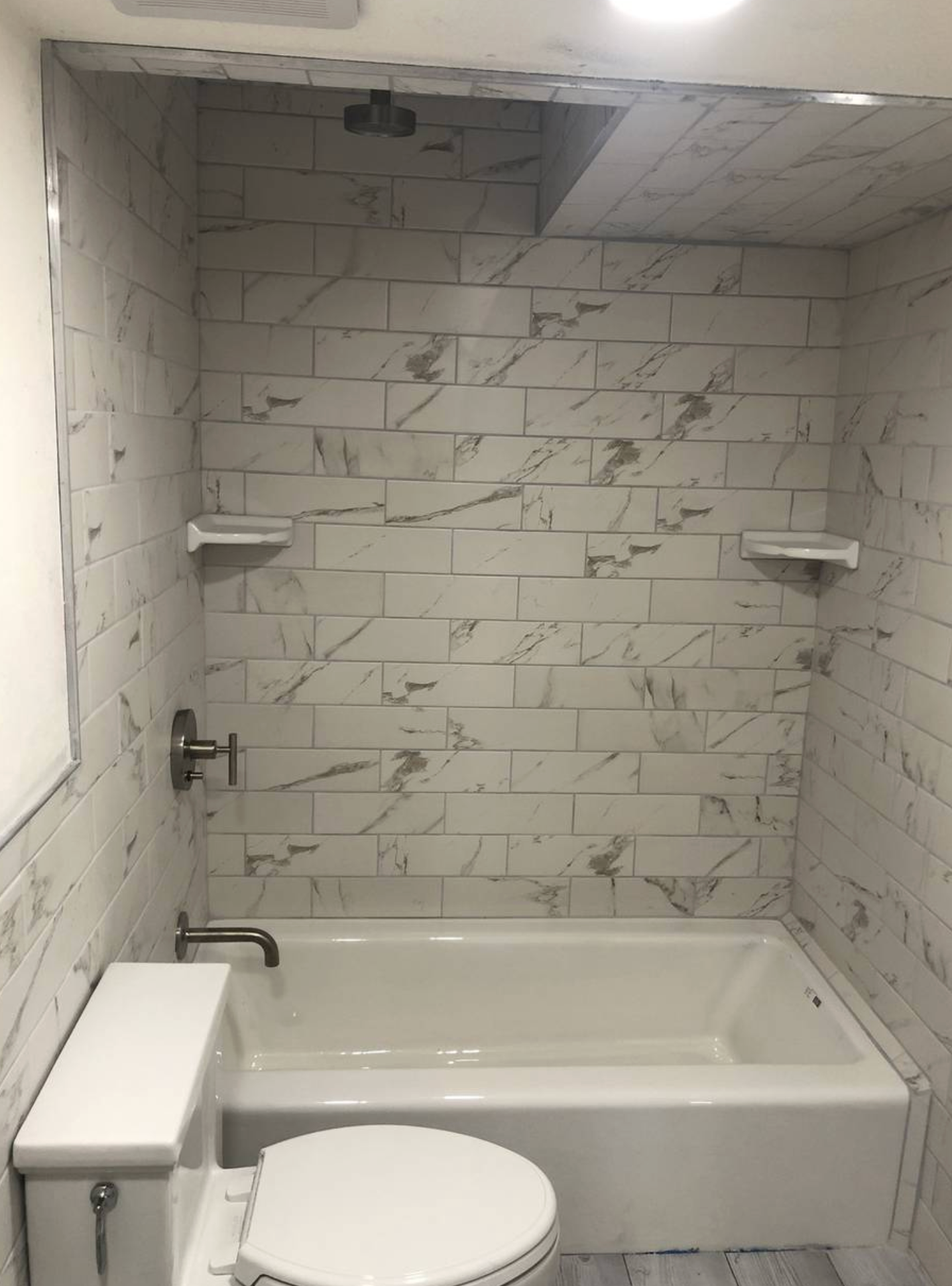 A bathroom with a toilet , bathtub and shower.