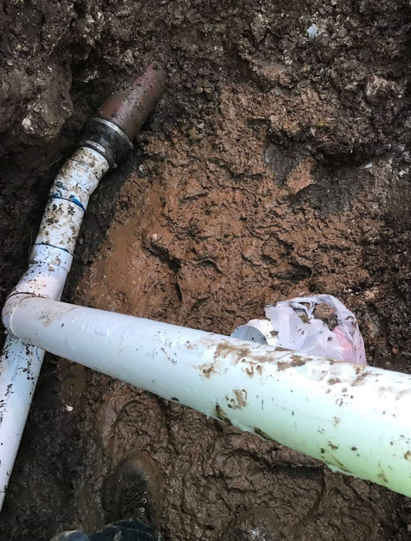 A couple of pipes are laying in the dirt.