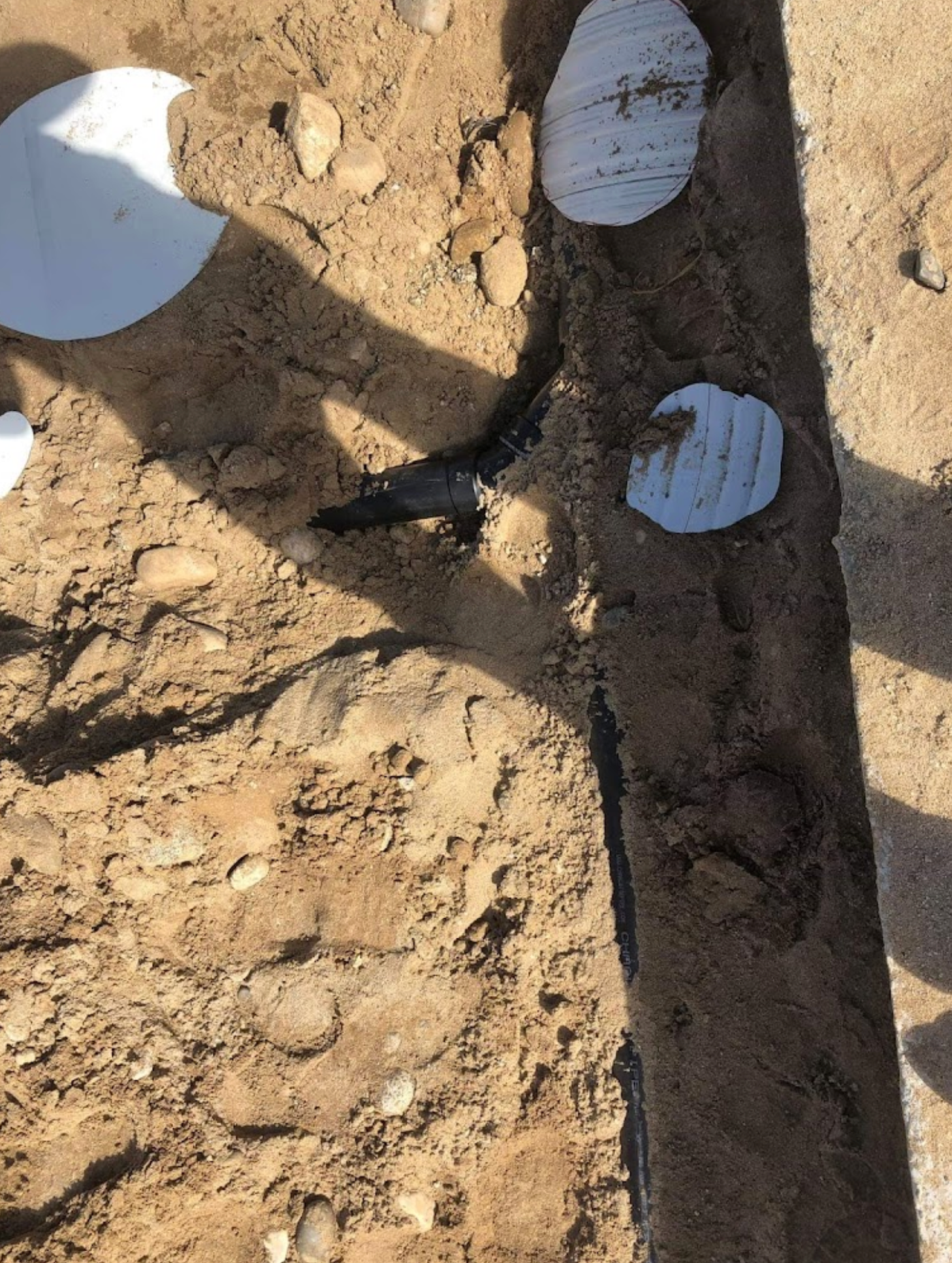 A person is digging in the dirt with a shovel.