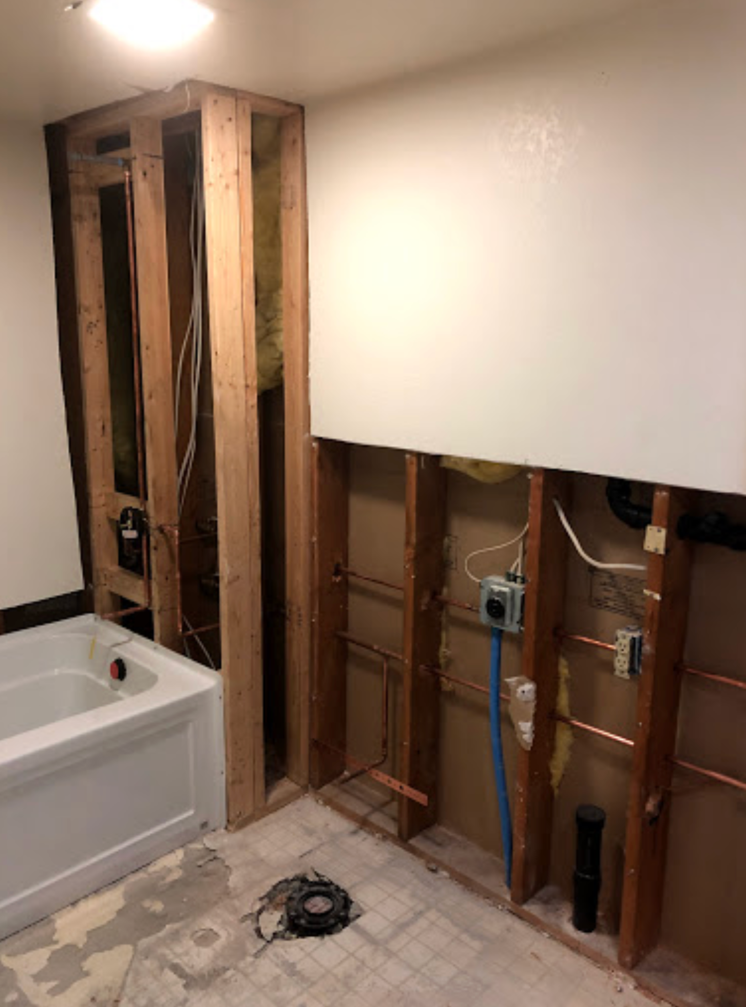 A bathroom under construction with a bathtub and wooden walls.