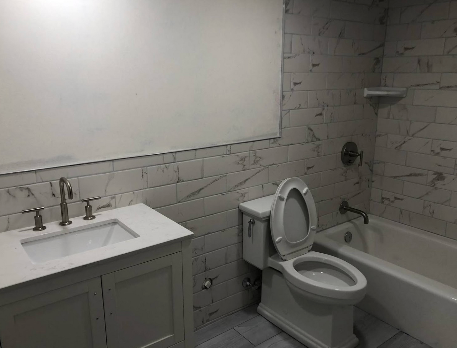 A bathroom with a toilet , sink and bathtub.