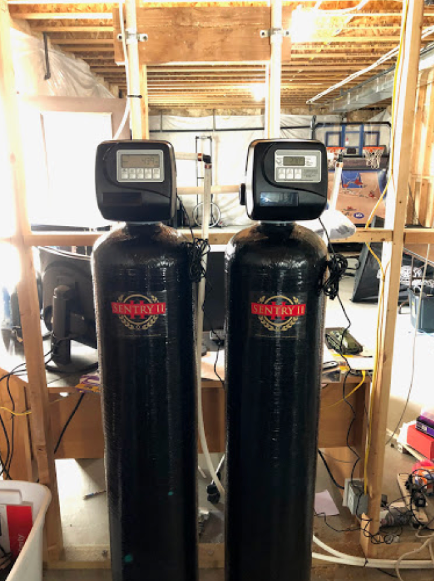 Two water softeners are sitting next to each other in a room.