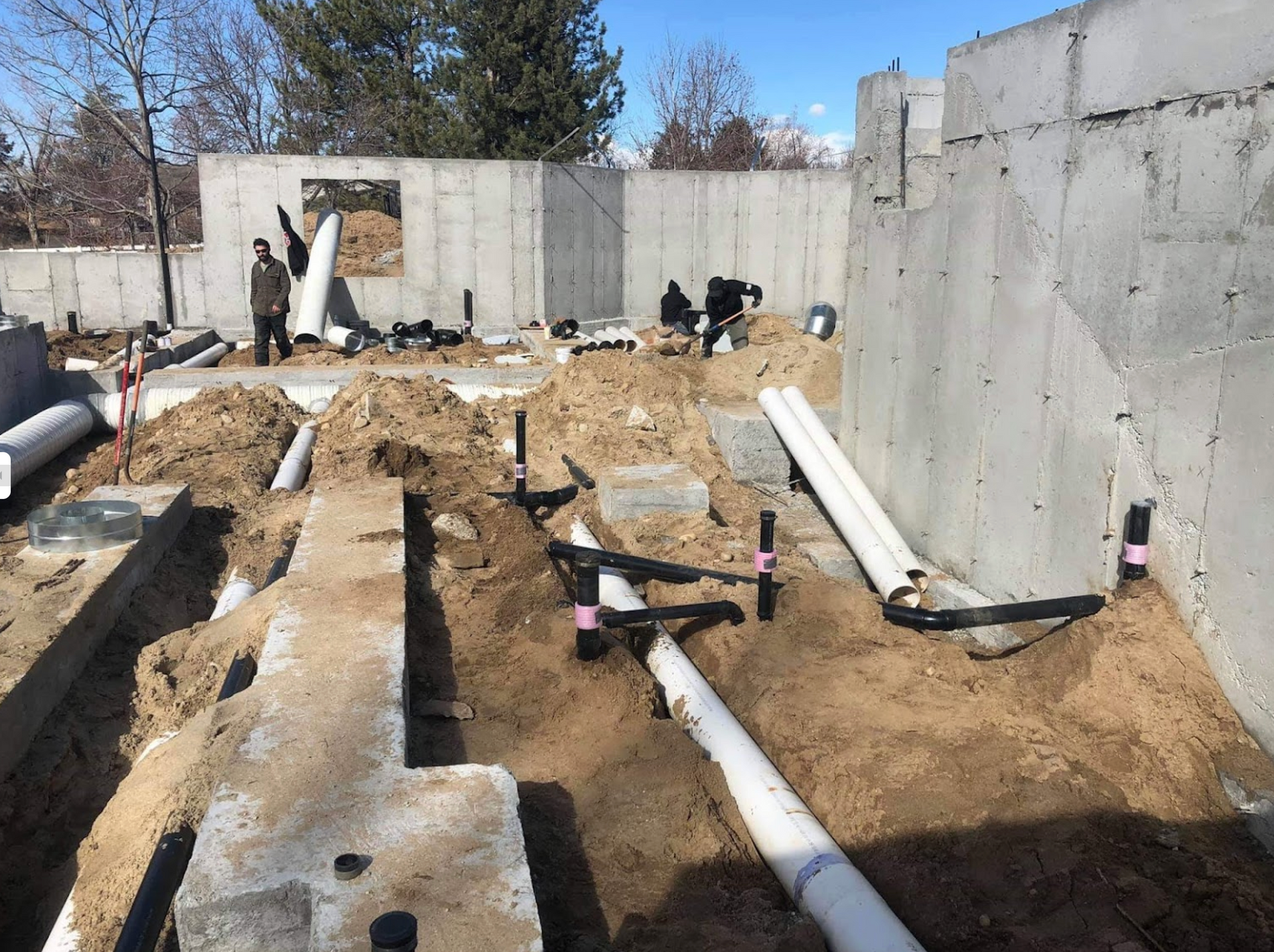 A construction site with a lot of pipes in the dirt
