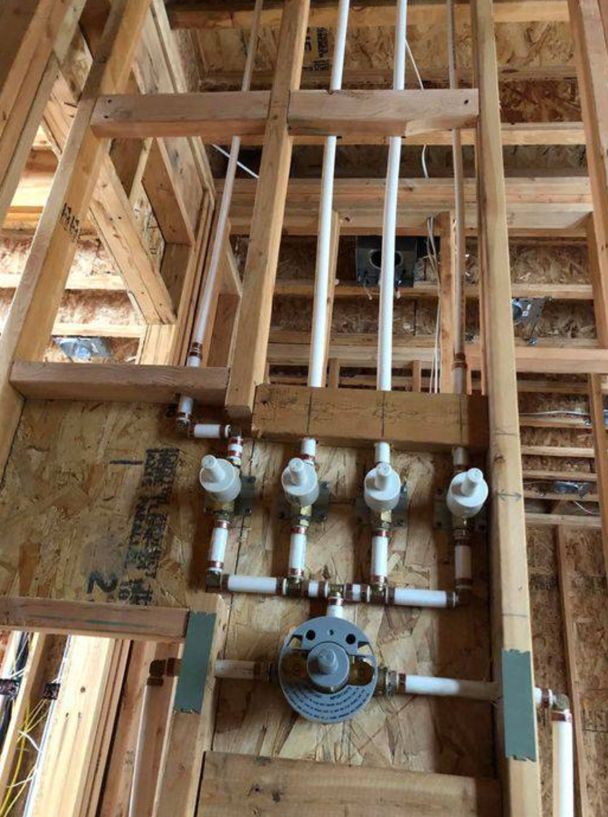 A bunch of pipes are hanging from the ceiling of a wooden building.