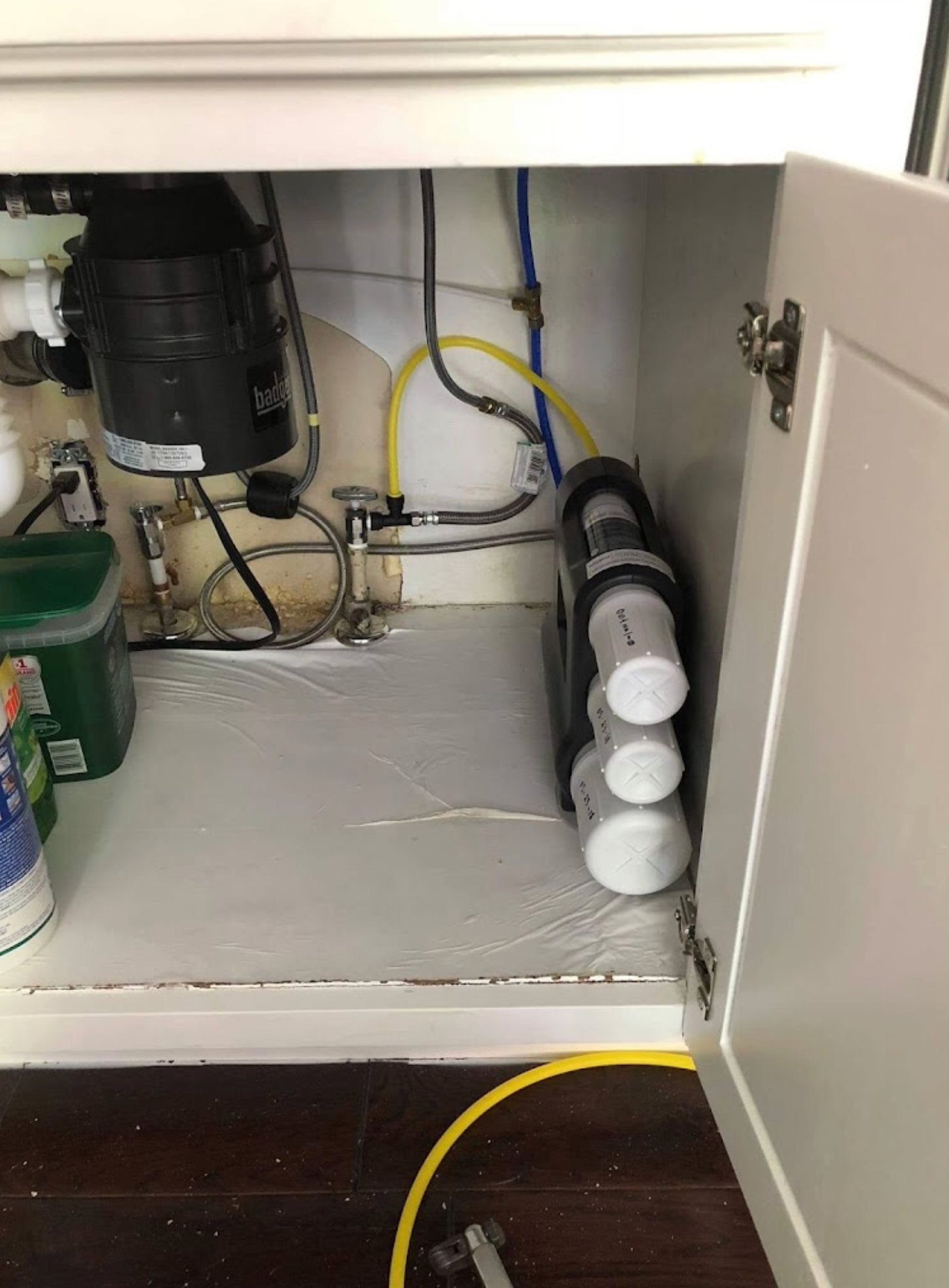 A kitchen sink with a water filter underneath it.