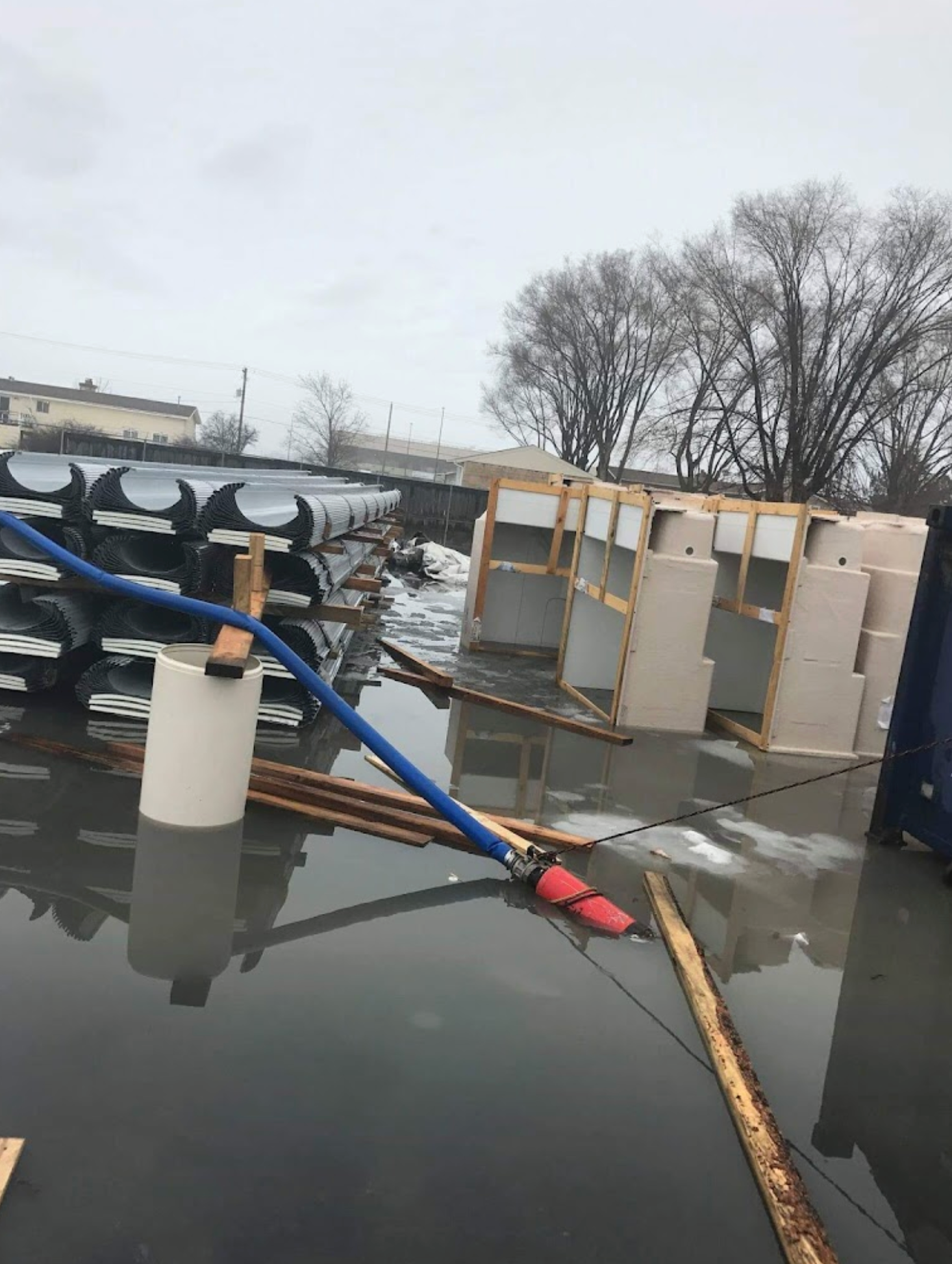 A warehouse is flooded with water and a hose is connected to it.