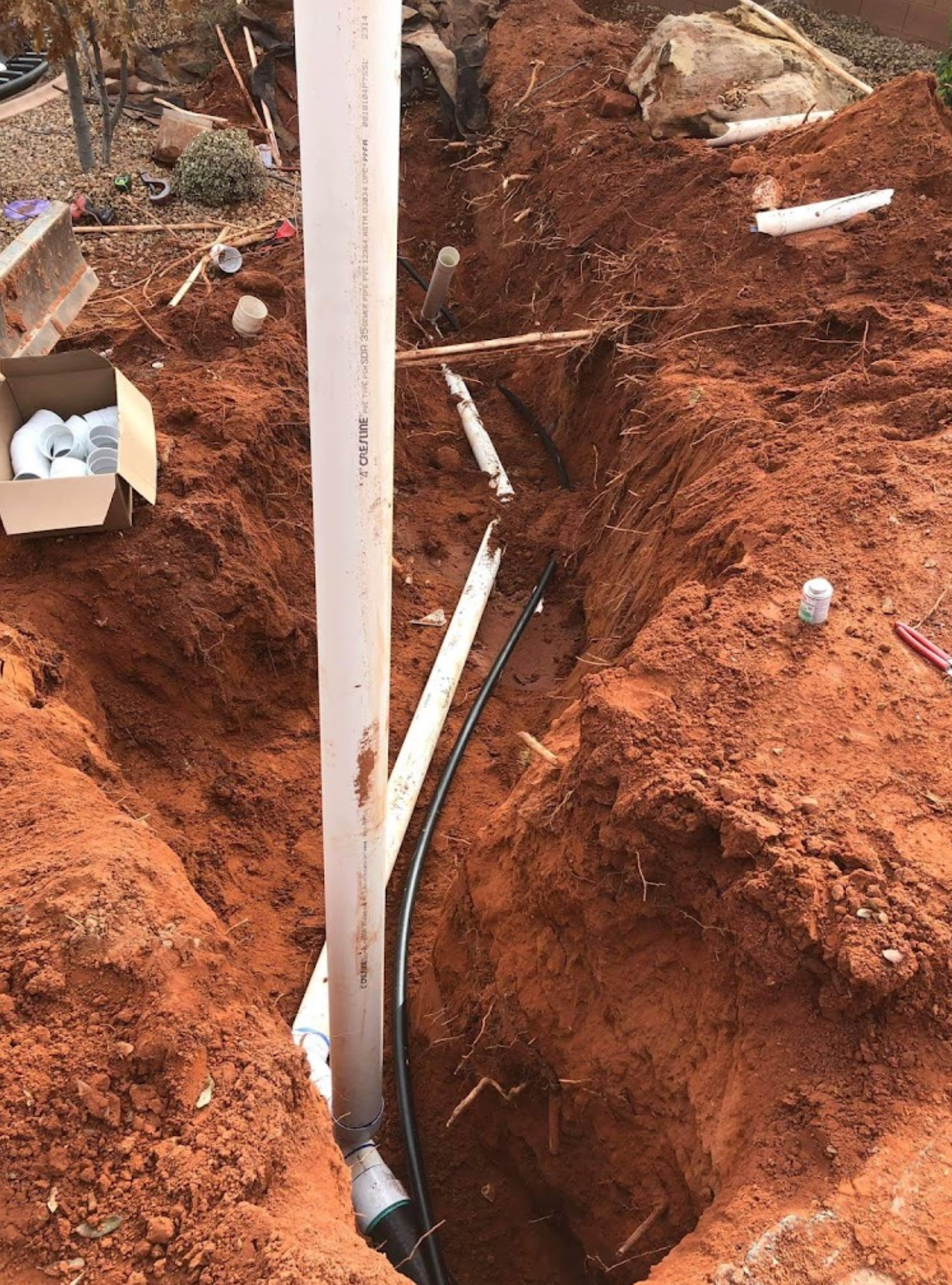 A pipe is being installed in a hole in the ground.