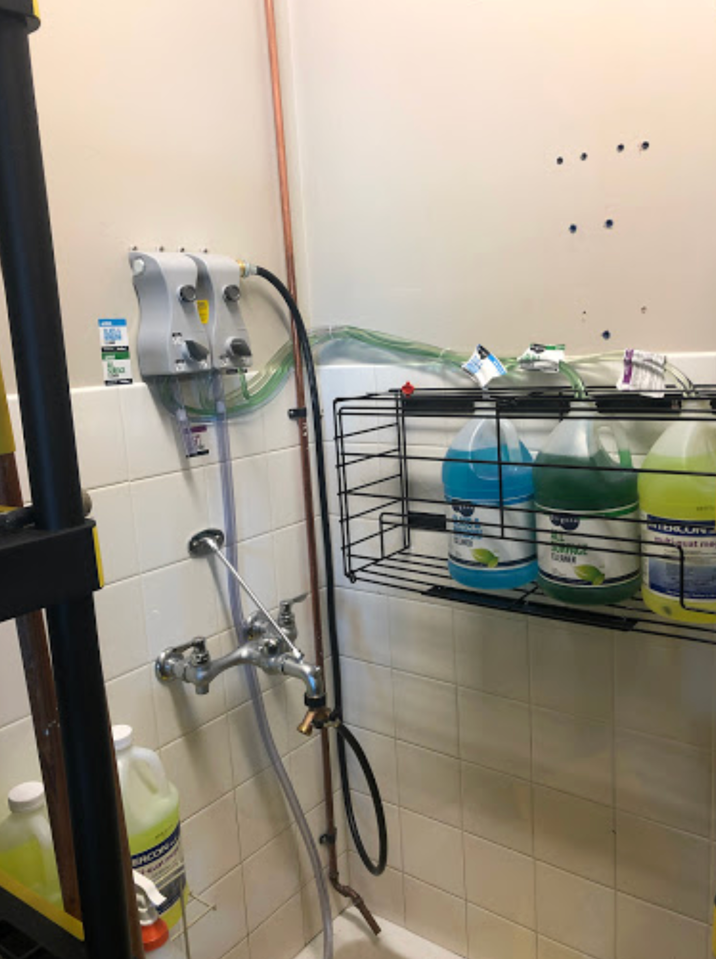 A bathroom with bottles of cleaning supplies on a shelf