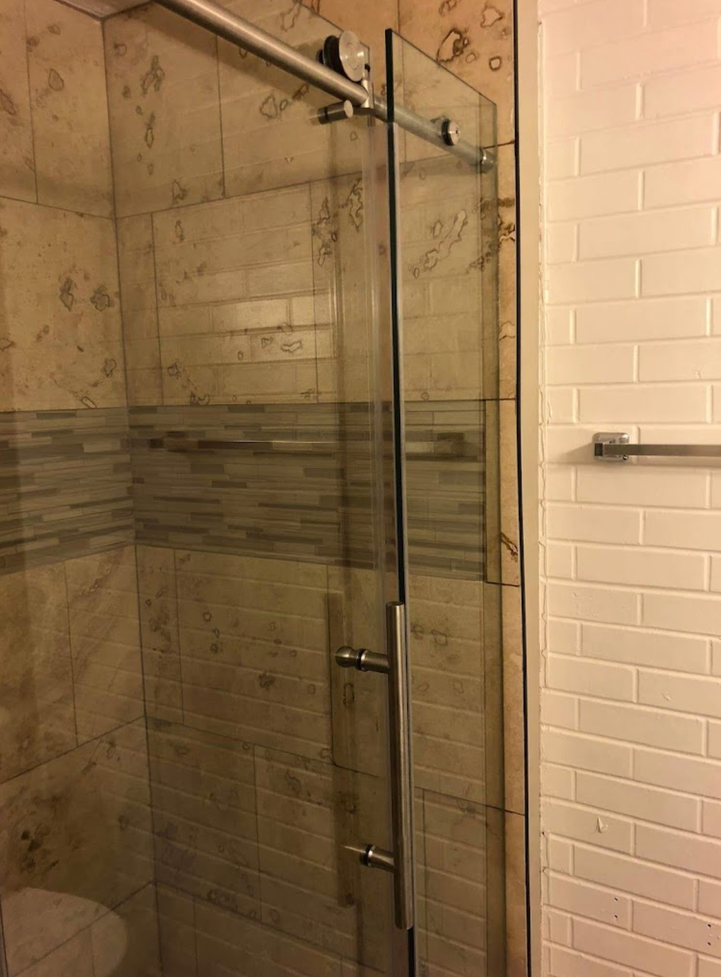 A bathroom with a sliding glass shower door