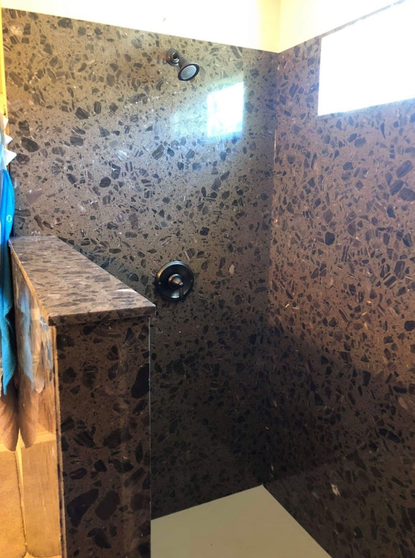 A bathroom with a walk in shower and a window.